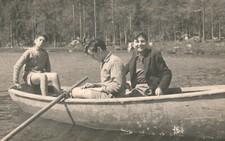 Boys on boat by lake forest