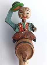 Cappello meccanico uomo ribaltabile intagliato tappo bottiglia seduto su una botte di vino con tubo