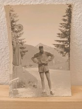 ciclista posa davanti insegna telefono a gettoni bar con ombrelloni  Italia '50