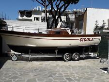 una imbarcazione gozzo in legno con motore entrobordo metri sette