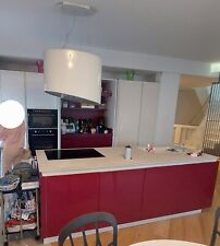 Cucina lineare con  isola bianca e bordeaux.