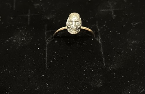 Anello dorato con - con, teschio