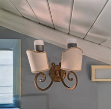 Elegante applique da parete con struttura in ferro battuto e finiture dorate. Id