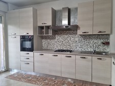 Cucina completa angolare con frigo, forno e piano cottura. Colore pino chiaro