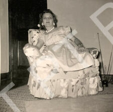 Foto vintage di una bella giovane donna seduta in poltrona che indossa un vestito anni 50