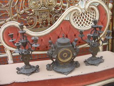 TRITTICO OROLOGIO E 2 CANDALABRI IN BRONZO CON FIGURE E TESTINE - 1920 EMILIA