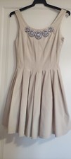 Abito beige con gioiello