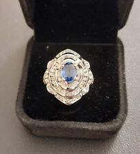 Anello in oro bianco, con zaffiro blù e contorno di diamanti carrè e brillante.