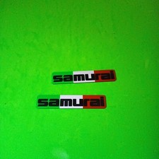 COPPIA 2 TARGHETTE LATERALI SUZUKI SAMURAI LOGO FREGIO STEMMA TARGHETTA LATERALE