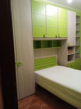 Cameretta a ponte verde compresa di scrivania, sedie, coperta su misura, ecc.