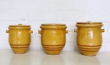 Antiche pentole francesi in confit con coperchi colore giallo caldo con decoro anello dipinto