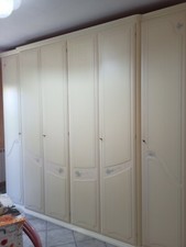 Camera da letto con armadio, comò, comodini e specchio.