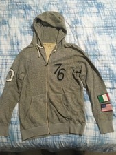 Felpa grigia sportiva con scritte, numeri e bandiere