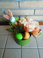 Centrotavola pasquale su base in latta con fiori artificiali, coniglio e uova