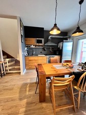 cucina industrial in legno con frigorifero, cappa e forno in acciaio.  