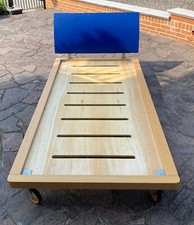 Letto singolo legno basso con rotelle doghe in faggio alzata color bleu.
