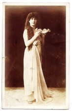 Donna in abito lungo con conchiglia in mano.