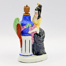 VILLAGGIO SEDUTO (?) Bottiglia profumo. Signora con pappagallo verde. Top corona. FREEPOST