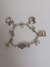 Bracciale Avon tono argento bambino charm scarpe rosa cavallo a dondolo orsacchiotto e altro