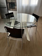tavolo rotondo in vetro e gambe in acciaio con sedie