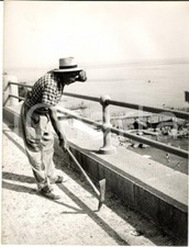 1955 ca GENOVA Operaio al lavoro mentre i bagnanti si divertono *Foto ARTISTICA