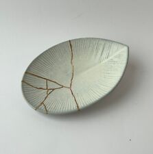 Piattino di porcellana giapponese a forma di foglia, rotta e riparata Kintsugi.