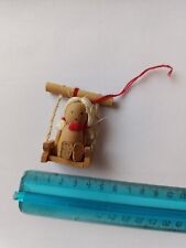 Bambolina in legno su altalena vintage