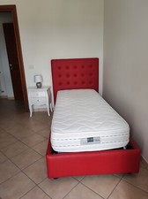 letto singolo rosso in ecopelle piú rete con doghe in legno, come nuovo