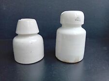 Due isolatori elettrici in ceramica bianca.