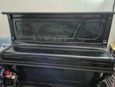 pianoforte verticale usato con seduta di colore nero 