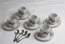 Cinque tazzine da caffé di ceramica con piattini e quattro cucchiaini