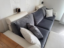 divano quattro posti in ecopelle bianco e alcantara grigia con cuscini e pouf