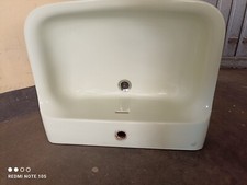 Un lavandino in ceramica colore verde chiaro munito di colonna