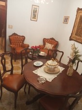 Sala con tavolo rotondo, 5 sedie e 2 poltrone imbottite, mobile vetrina, tavolin