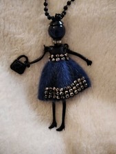 collana con bambolina,vestito blu in peluche, testa e collana nere. Molto lunga.