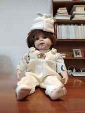 Bambolotto di porcellana in salopette bianca