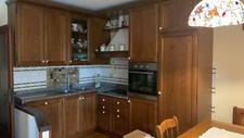 Cucina completa in legno massello con tavolo, sedie e panca angolare