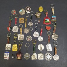 Lotto di 31 portachiavi, medaglie e spillini di montagna e sci smaltati ossidati