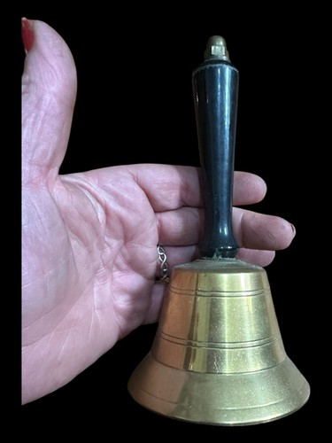 Old brass hand bell with - hand,