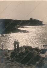 Uomini su uno scoglio riva