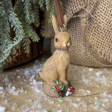 Coniglio seduto su tronco