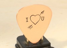 copper guitar pick with arrow through the heart