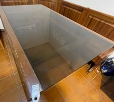 tavolo in legno massello con solido piano in vetro temperato scuro.