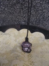 Pendente in ametista con gabbia e filo in tessuto.