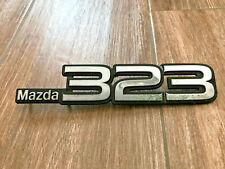 MAZDA 323 LOGO SIGLA EMBLEMA FREGIO STEMMA SCRITTA TARGHETTA BADGE TARGA PLACCA