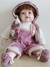 Bambolotto di porcellana in salopette rosa