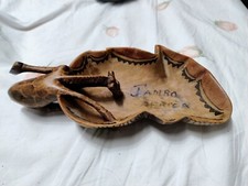 Giraffa in legno intagliata a mano che beve in una pozza. Artigianato africano