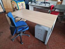 Scrivania da ufficio con sedia e cassettiera in metallo.