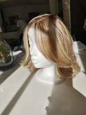 Parrucca di capelli sintetici biondo cenere con riflessi chiari.