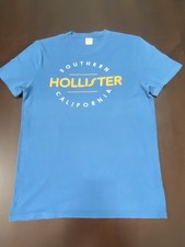HOLLISTER  T-SHIRT RAGAZZO TAGLIA M COLORE AZZURRO CON SCRITTA GIALLA E BIANCA